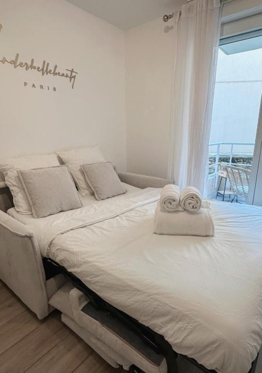 une chambre avec un lit avec des serviettes dessus dans l'établissement Charmant Studio avec Balcon, à Paris