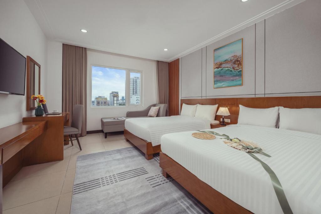 a hotel room with two beds and a television at Star Hotel and Spa Danang in Danang