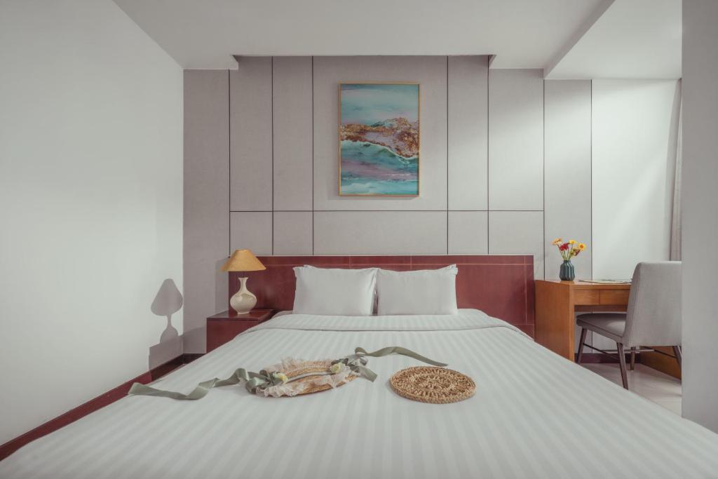 a bedroom with a bed with a plate of food on it at Star Hotel and Spa Danang in Danang