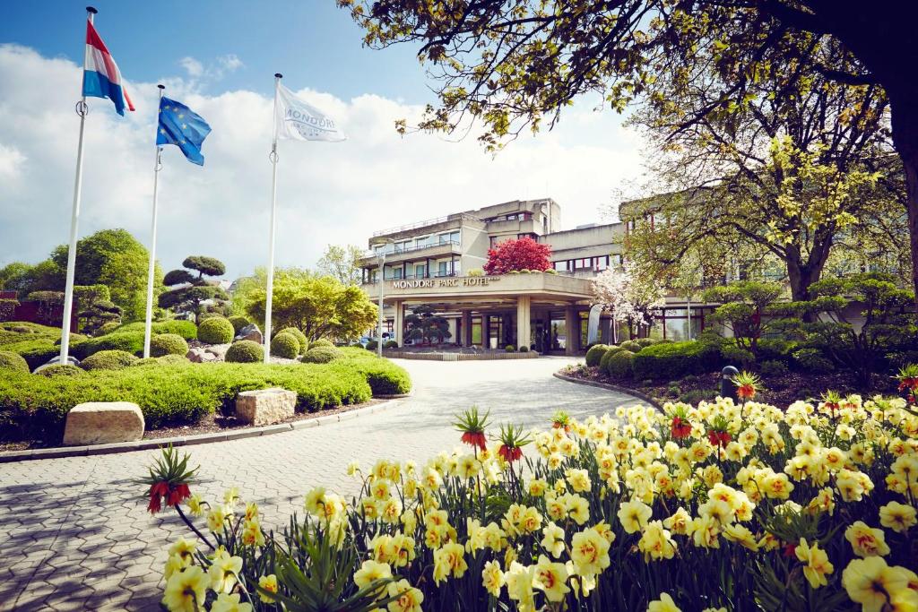 a garden of flowers in front of a building at Mondorf Parc Hotel & Spa in Mondorf-les-Bains