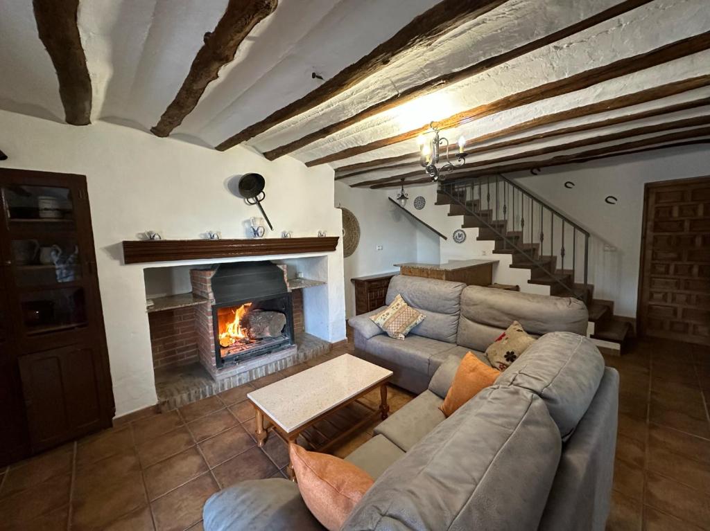 ein Wohnzimmer mit Couch und Kamin in der Unterkunft Casa Rural Cortijo El Helao in Pozo Alcón