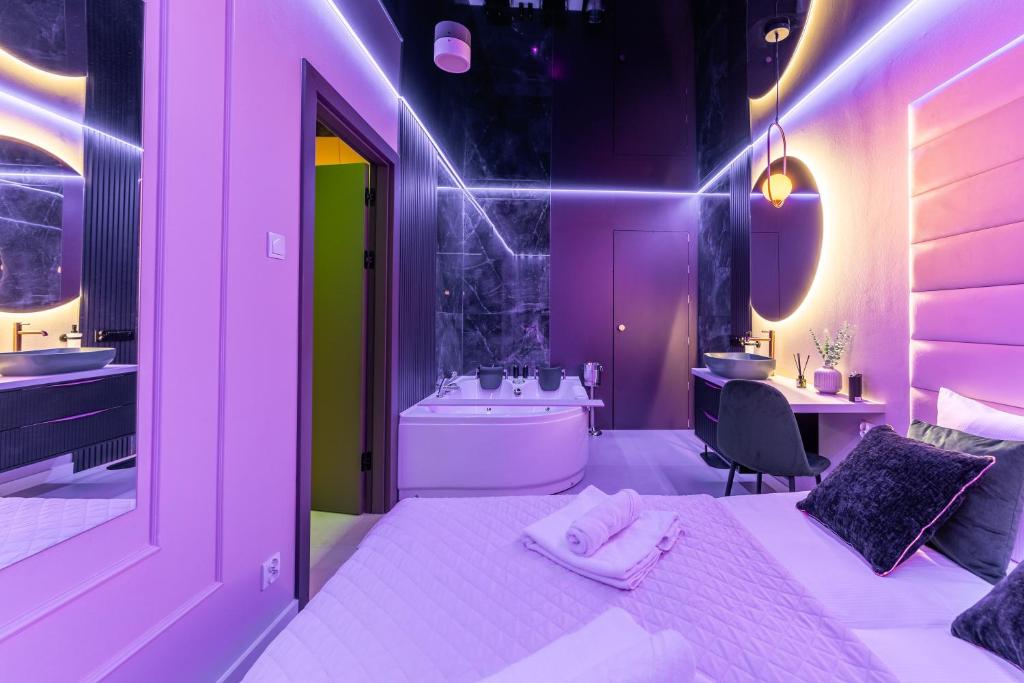 ein lila Badezimmer mit einer Badewanne und einem Waschbecken in der Unterkunft Apartamenty z Jakuzzi Perłowa Przystań Rent Kołłątaja in Kołobrzeg