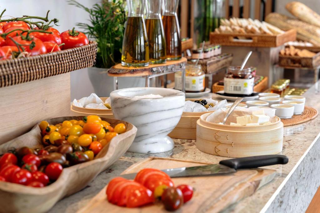 a counter topped with bowls of tomatoes and other vegetables at The Chedi Luštica Bay in Tivat