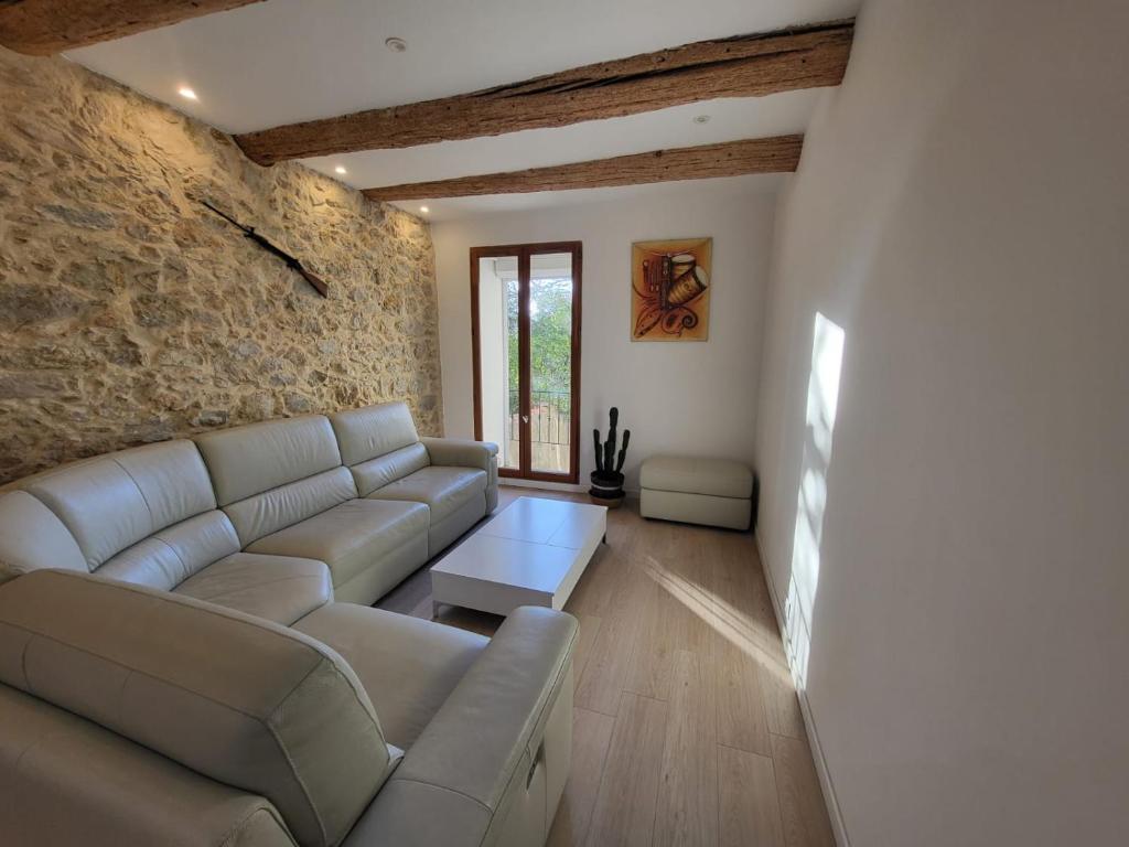 un salon avec un canapé et un mur en pierre dans l'établissement Jacuzzi, plage, vieux port, à Marseille