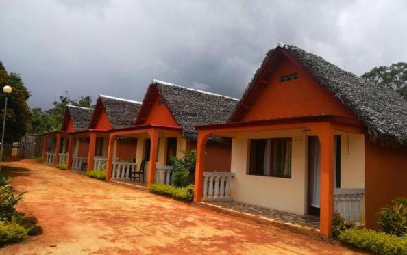 Une rangée de maisons à l'orange et au blanc dans l'établissement GO Andasibe Hotel, à Andasibe