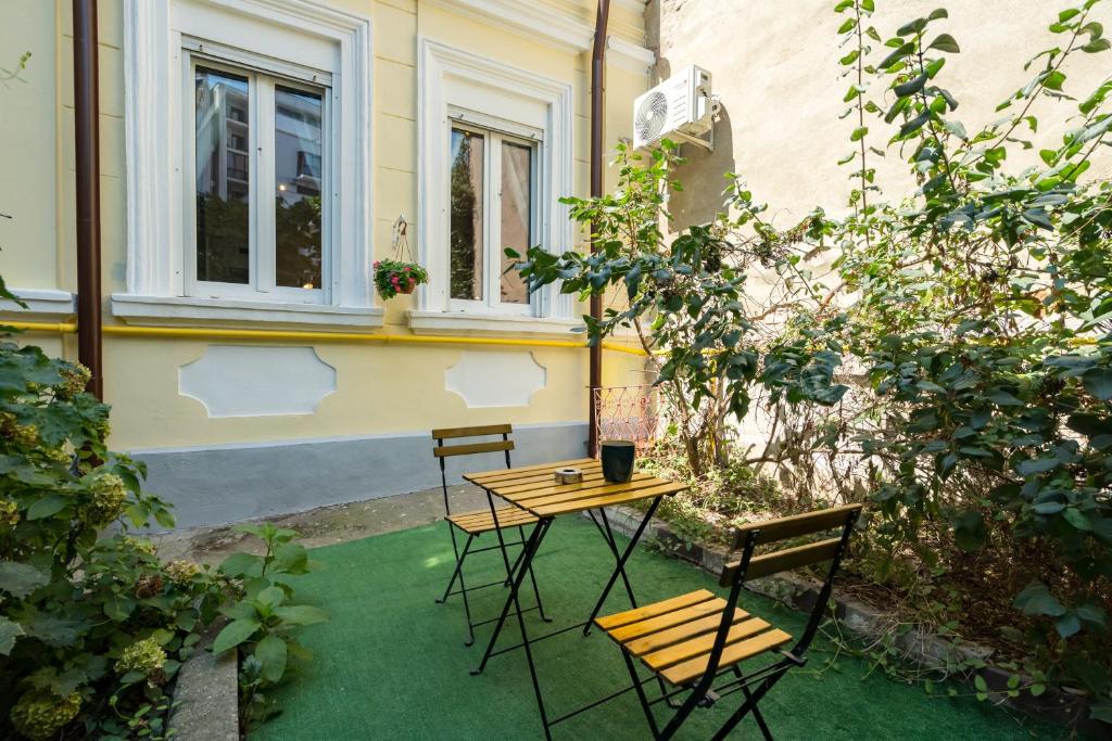 a patio with two chairs and a table and a table at Emil Balaban Luxury Apart-Hotel in Bucharest