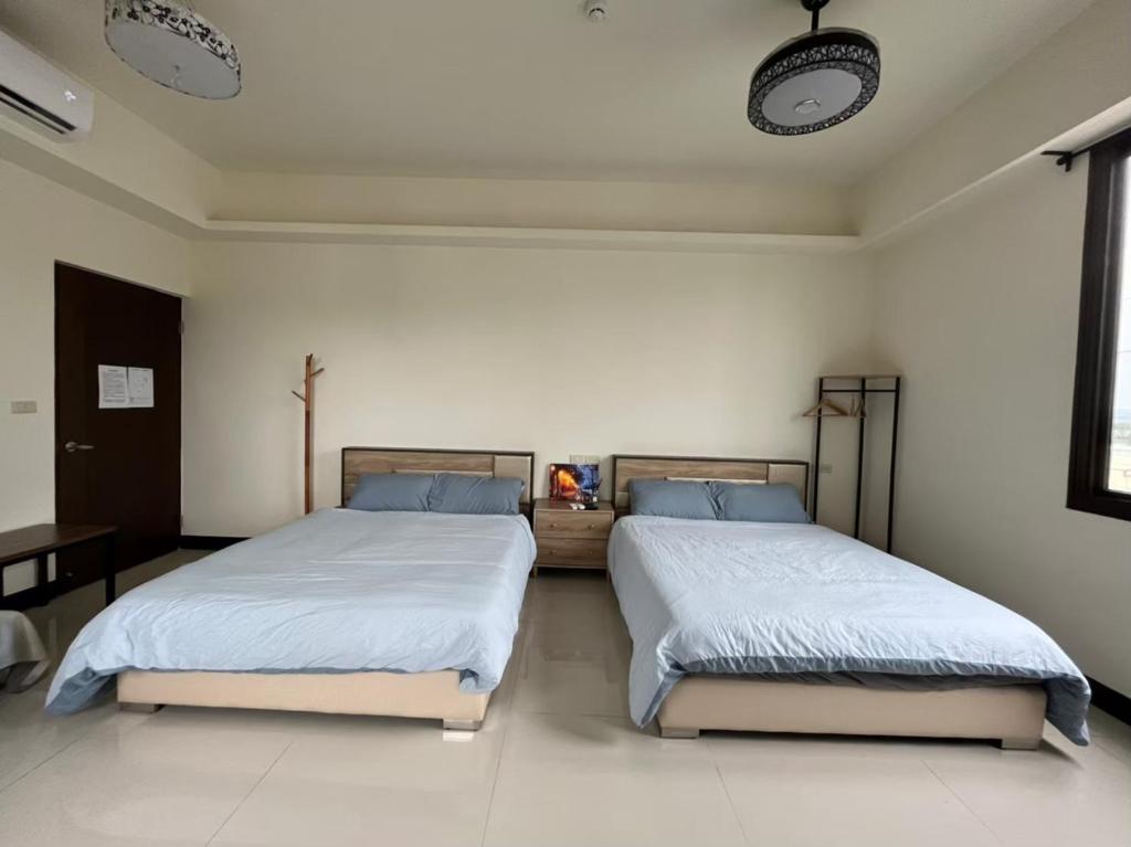 two beds in a white room with two beds sidx sidx sidx at Lucky House Homestay in Guilin