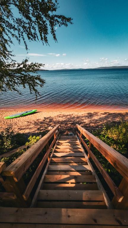 a wooden pathway to the beach with the water at Arctic Circle Beach House in Meltosjärvi
