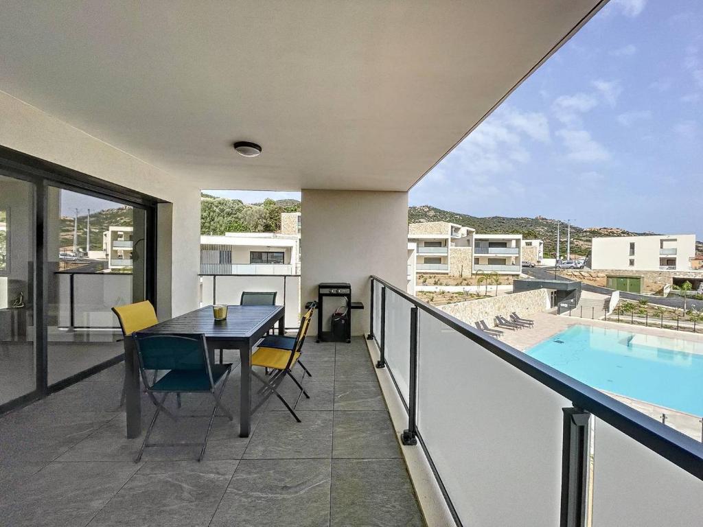 d'un balcon avec une table et des chaises, ainsi que d'une piscine. dans l'établissement Grand T3 vue sur la baie de Calvi, à Calvi