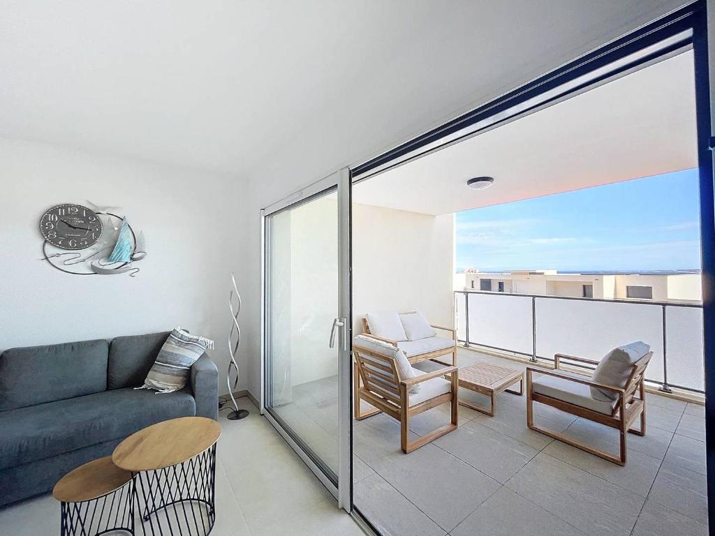 un salon avec un canapé et une table dans l'établissement T3 vue sur la baie de Calvi, à Calvi