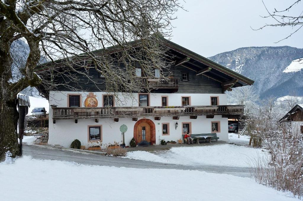 a large white house with snow on the ground at Demeterhof Knolln in Söll