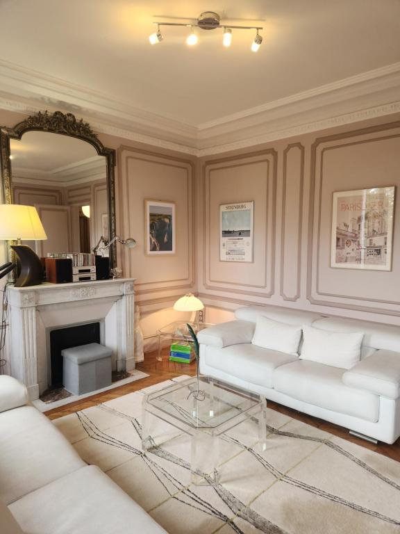 un salon avec un canapé blanc et une cheminée dans l'établissement Appartement Haussmannien, à Charenton-le-Pont