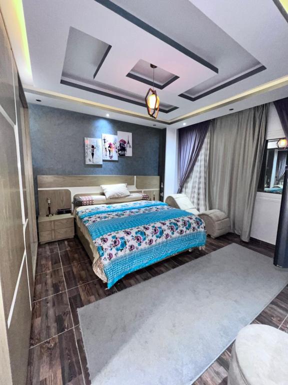 a bedroom with a large bed with a blue comforter at Villa Contenental residense El sheikh Zayed Beverly Hills in Sheikh Zayed