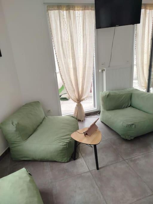un salon avec un canapé vert et une table dans l'établissement HOMEYPIC Villeurbanne T4 proche INSA, à Villeurbanne