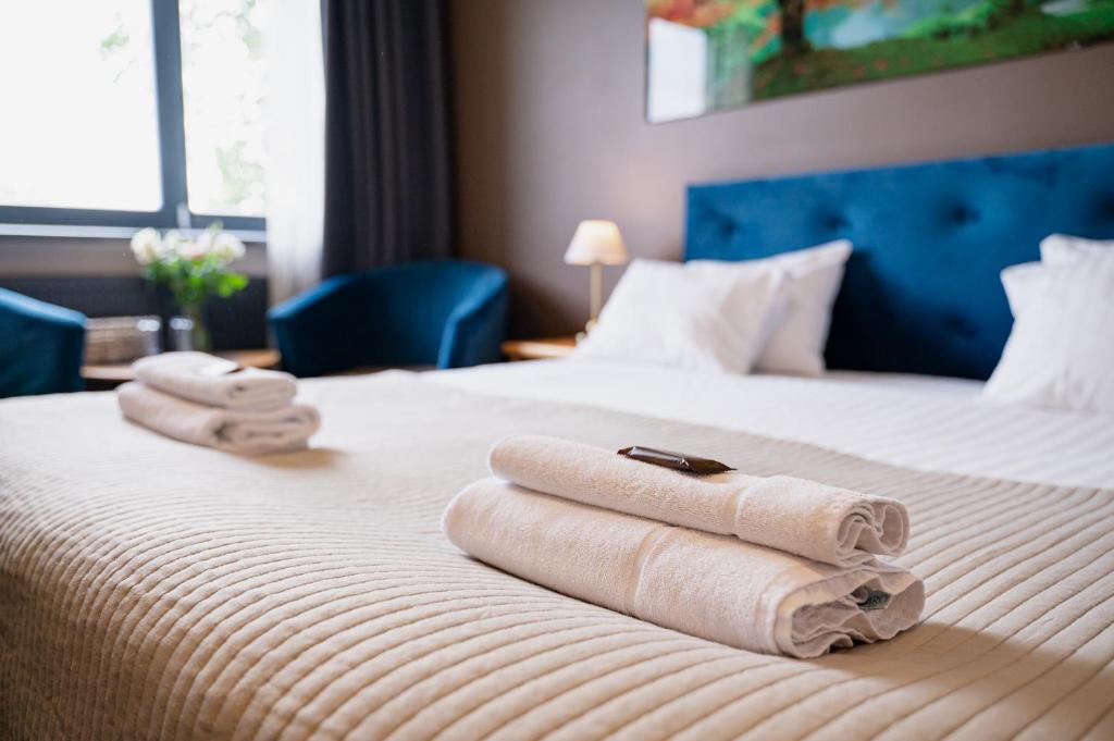 a hotel room with a bed with towels on it at Comfort Hotel Kuldiga in Kuldīga