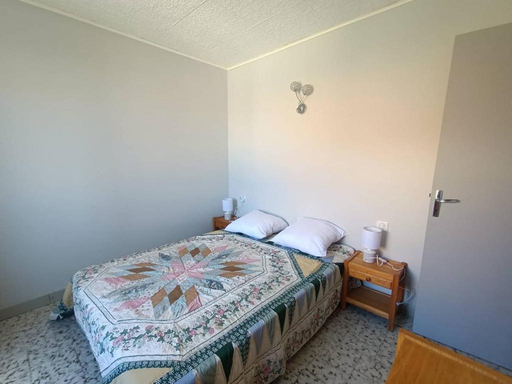 sypialnia z łóżkiem i stołem z 2 poduszkami w obiekcie Maison de Famille Vintage à 100m de la Plage 10ARGO82 w mieście Saint Pierre La Mer
