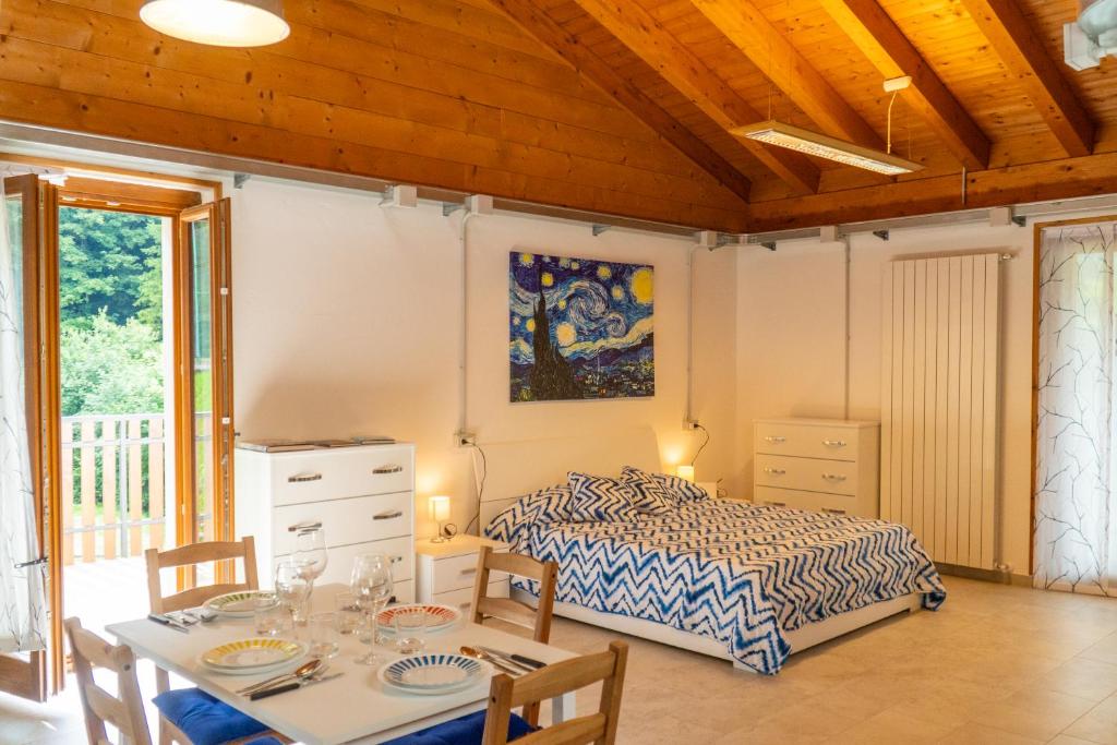 a bedroom with a bed and a table with chairs at appartamento Van gogh in Oltre il Colle