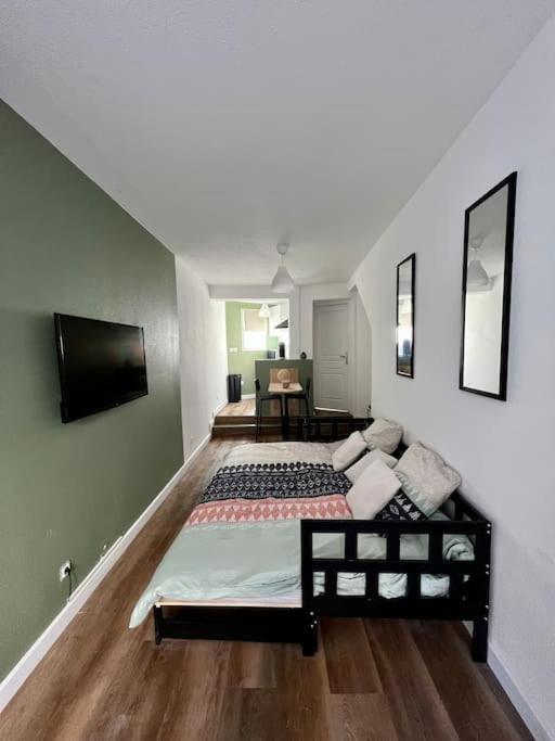 - une chambre avec un grand lit et une télévision dans l'établissement Appartement plein centre-ville, à Mulhouse