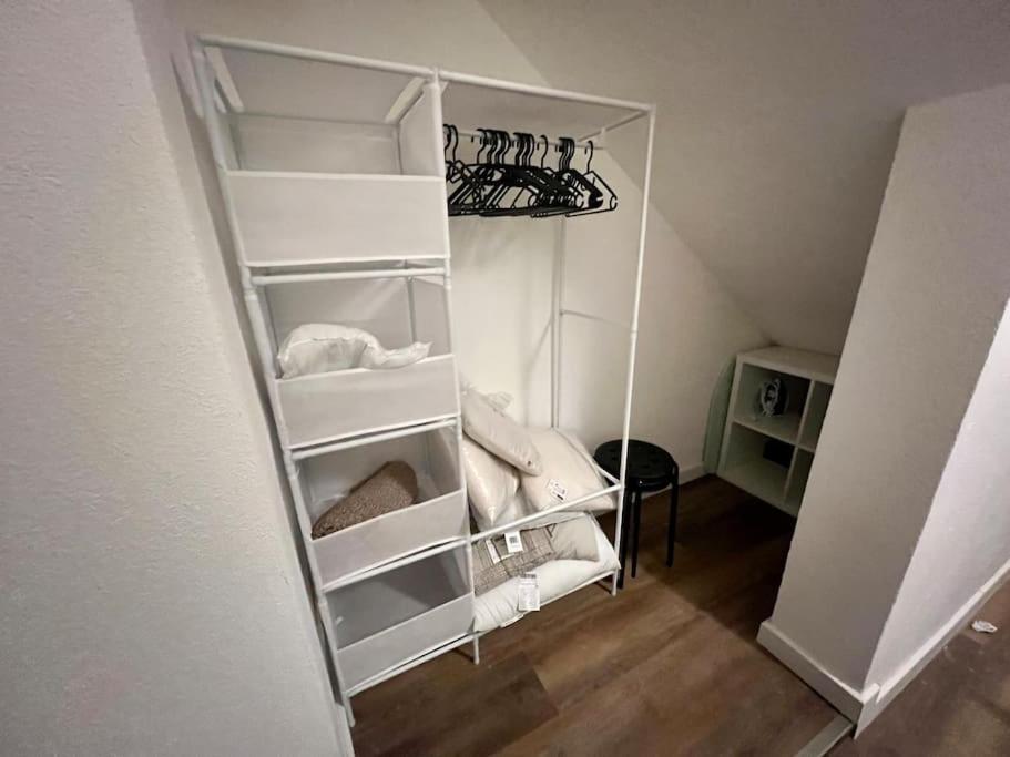 a white closet with white shelves in a room at Appartement plein centre-ville in Mulhouse