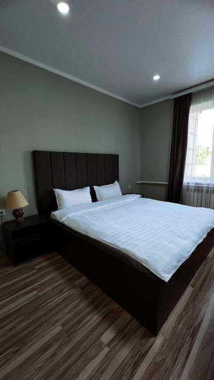 a bedroom with a large bed with white sheets at Travel Point hotel in Bishkek
