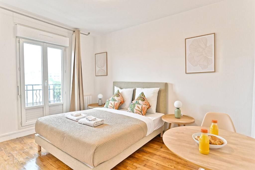 une chambre avec un lit, une table et une fenêtre dans l'établissement Studio agréable et tout équipé à Montreuil - II, à Montreuil