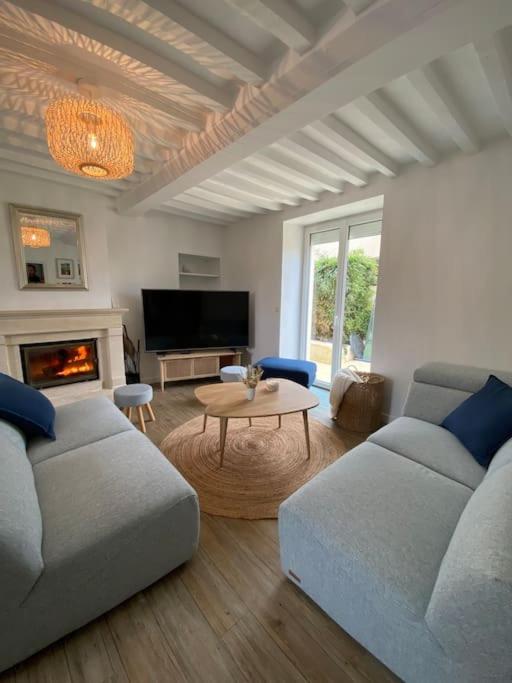 un salon avec deux canapés et une table dans l'établissement L escapade, à Grandcamp-Maisy