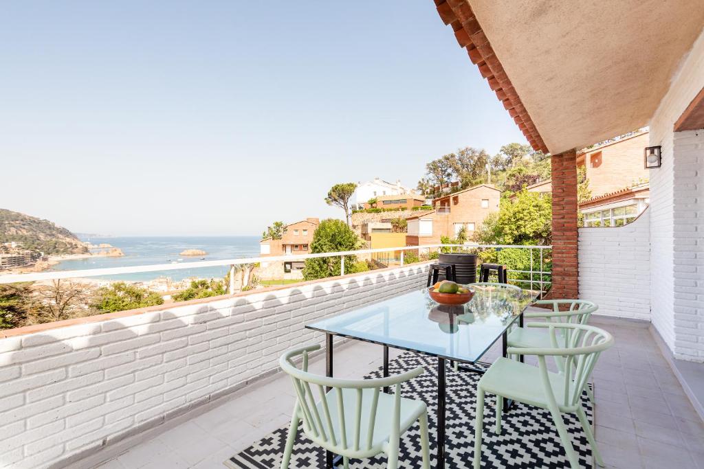 a patio with a table and chairs and the ocean at Torre Mirador Azul 2 habitaciones in Tossa de Mar