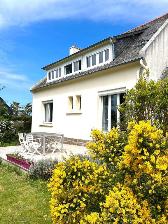 une maison blanche avec un banc devant dans l'établissement Maison 2 pers avec jardin clos, terrasse à TREBEURDEN - Réf 671, à Trébeurden
