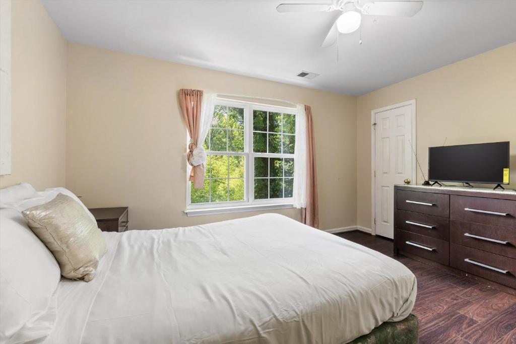 a bedroom with a white bed and a window at Entire 4-BR in Beloved DC Area Takoma Park in Takoma Park