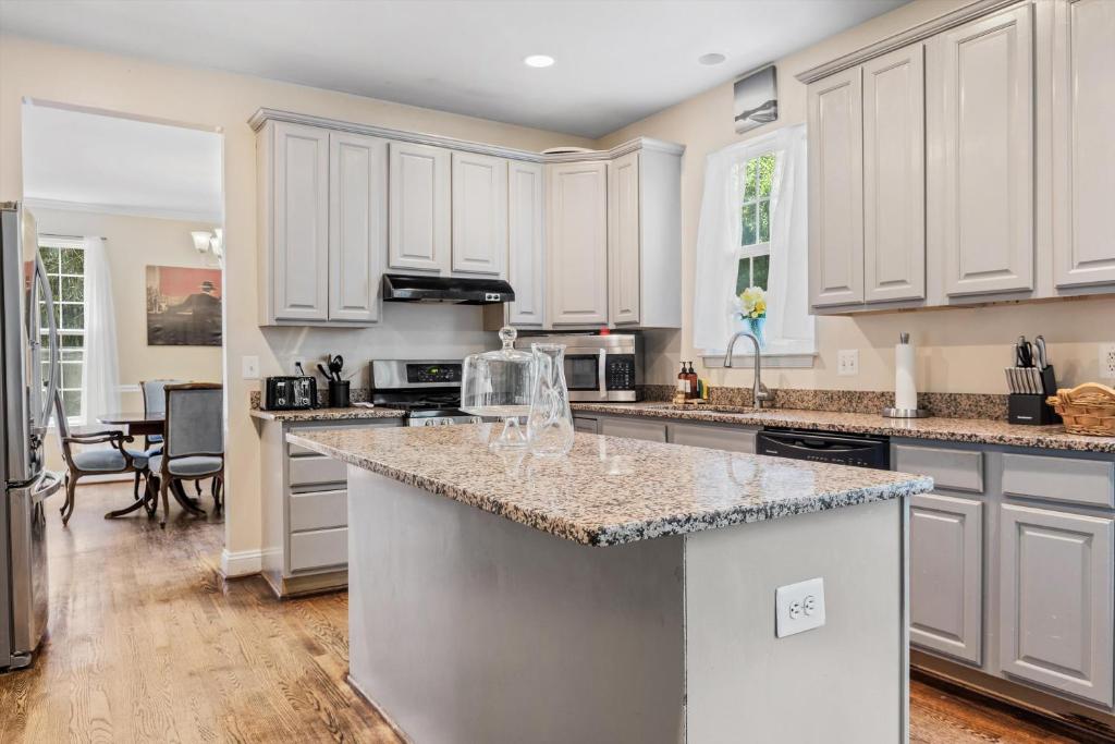 a kitchen with white cabinets and a granite counter top at Entire 4-BR in Beloved DC Area Takoma Park in Takoma Park