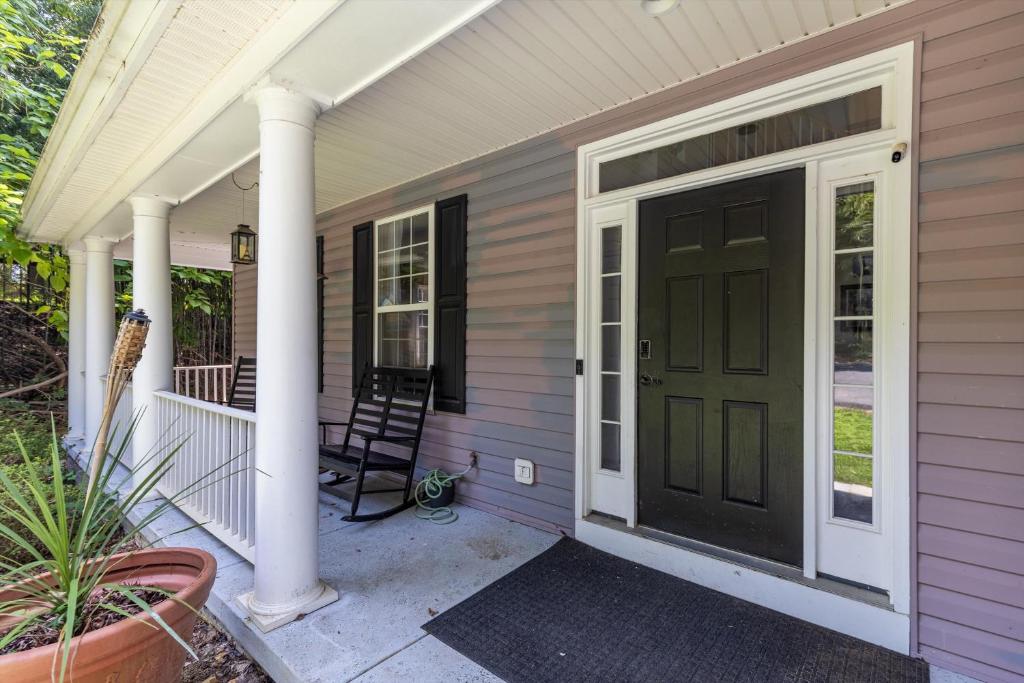a front porch with a black door and columns at Entire 4-BR in Beloved DC Area Takoma Park in Takoma Park