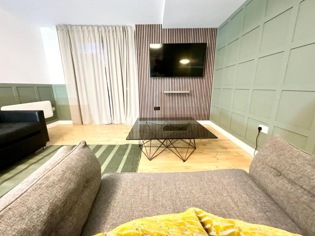 Hotel Private Garden Apartment with Geodome, a living room with a couch and a tv at Private Garden Apartment with Geodome in Manchester