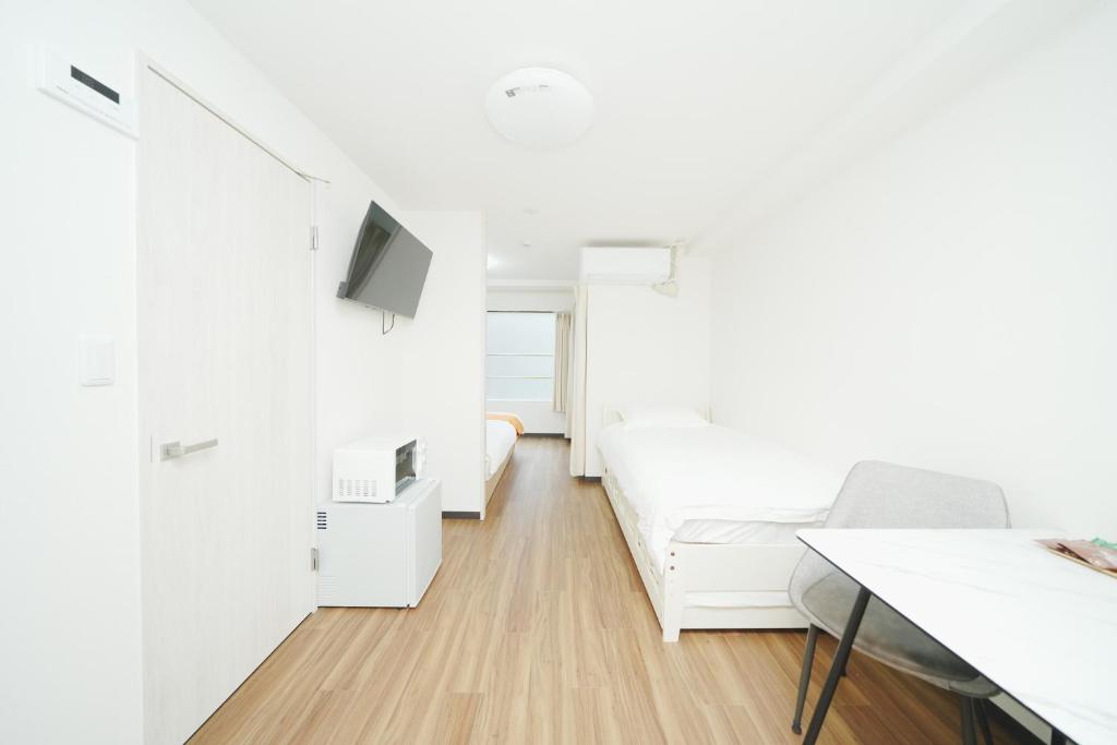 a white room with a bed and a desk at 東京リリアルホテル201 in Tokyo