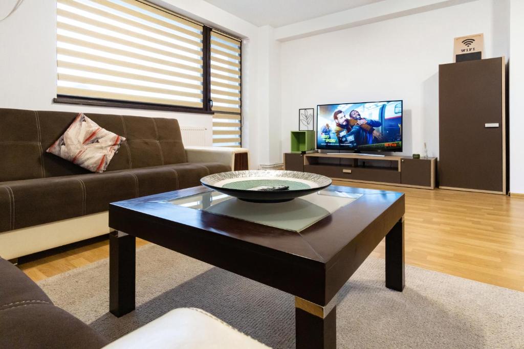 a living room with a couch and a coffee table at Central Apartments - Green in Bacău