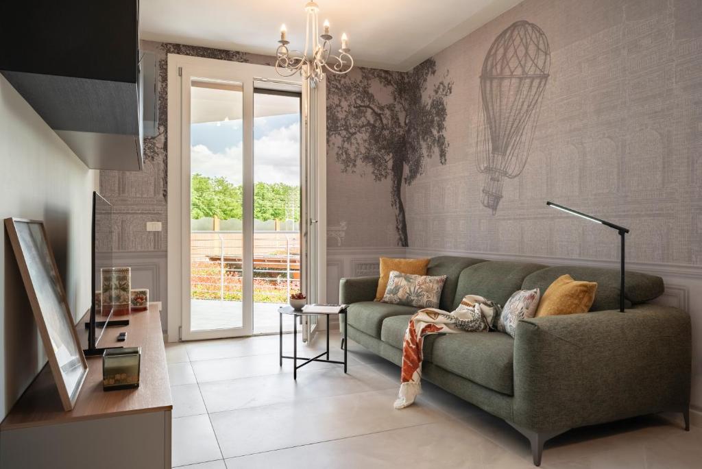 a living room with a green couch and a window at Apartment Il Giglio in Montelupo Fiorentino