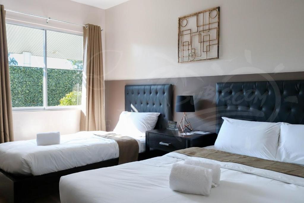 Postel nebo postele na pokoji v ubytování Bumble V Subic Hotel