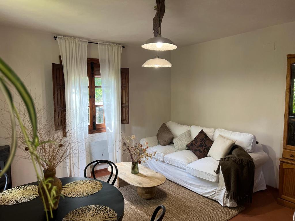 a living room with a white couch and a table at Mevak Home Alpujarra in Pórtugos