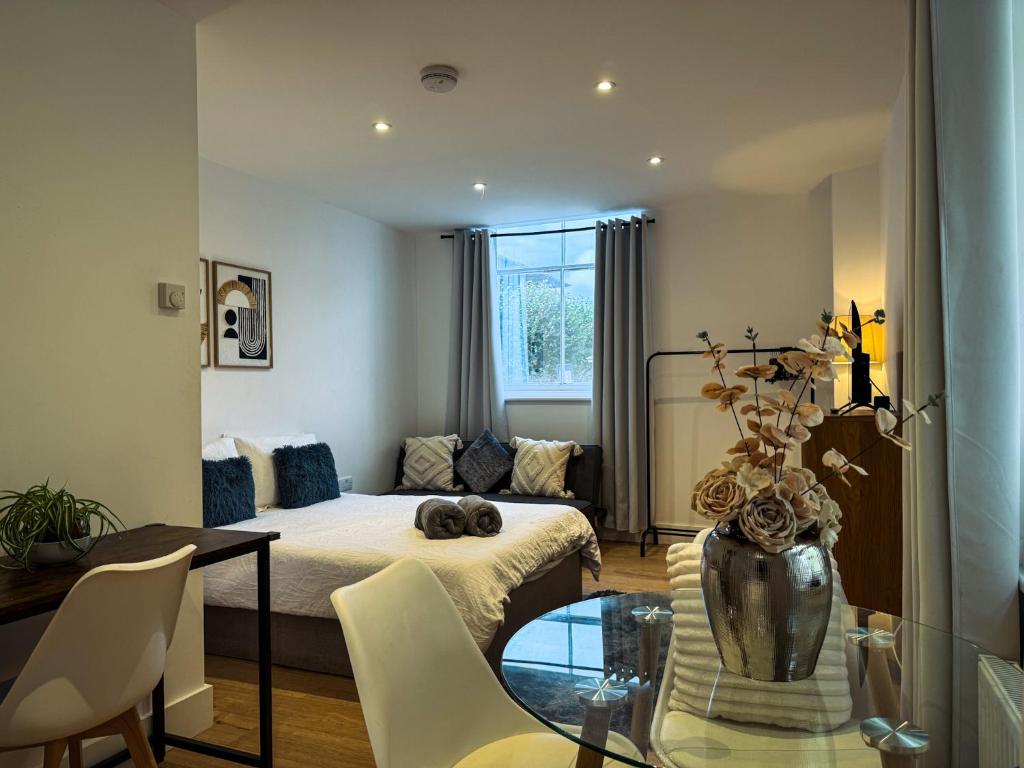 a room with a bed and a table and chairs at Beautifully Central & Superior Apartment Book Now in Kent