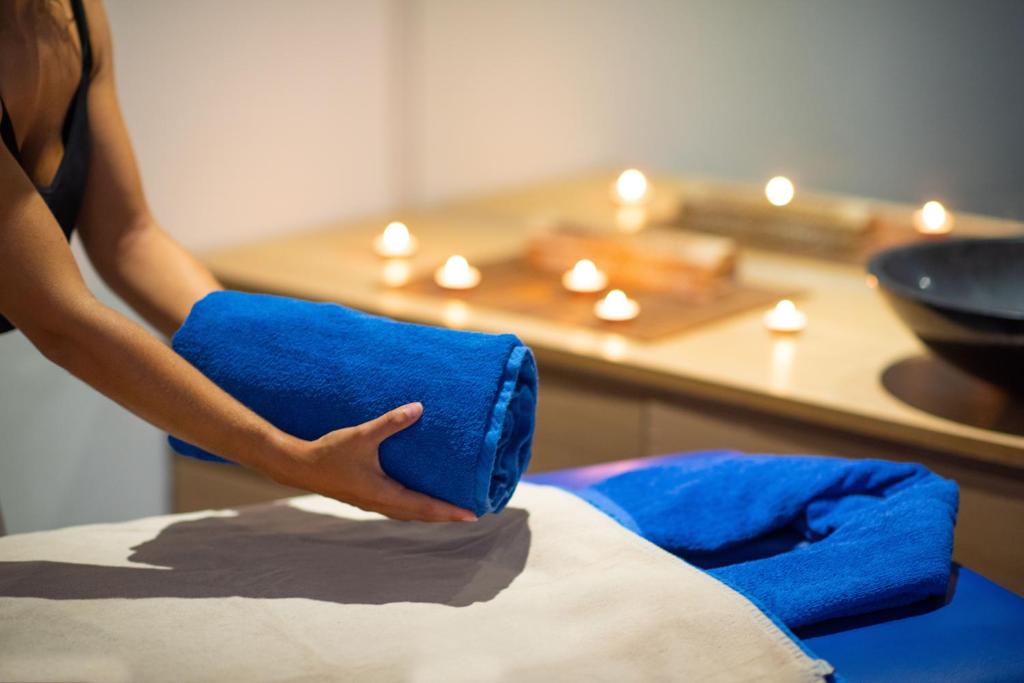 a woman holding a blue pillow on top of a bed at Olé Tropical Tenerife Adults Only in Playa de las Americas