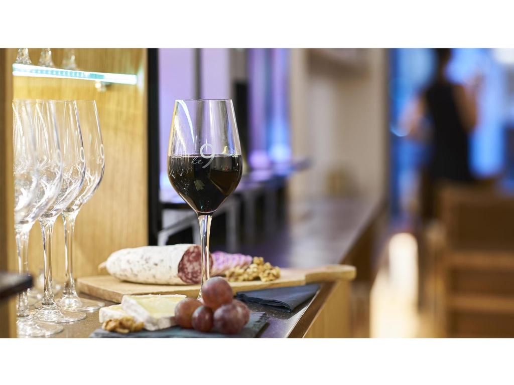 a glass of wine sitting on a table with wine glasses at 9Hotel Republique in Paris