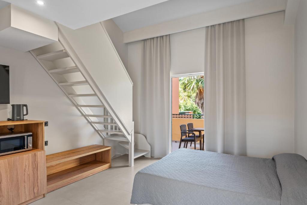 una camera con letto e scala di Aqualand Resort ad Ágios Ioánnis
