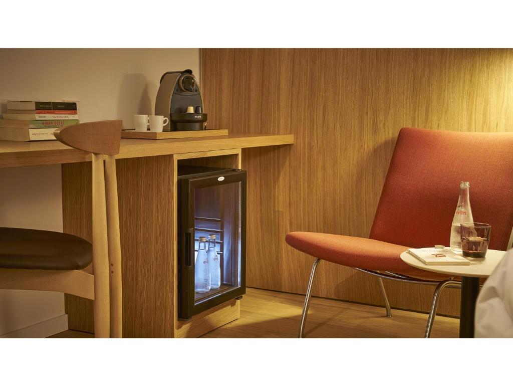 a room with a fireplace with two chairs and a table at 9Hotel Republique in Paris
