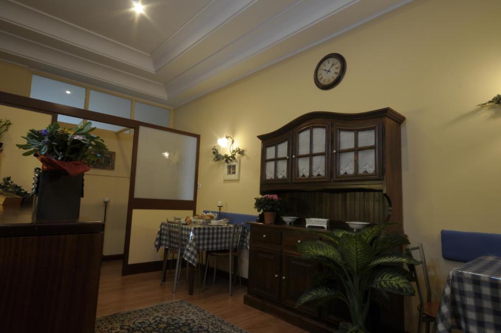 Pokój ze stołem i zegarem na ścianie w obiekcie Monteoliveto Bed & Breakfast w mieście Napoli