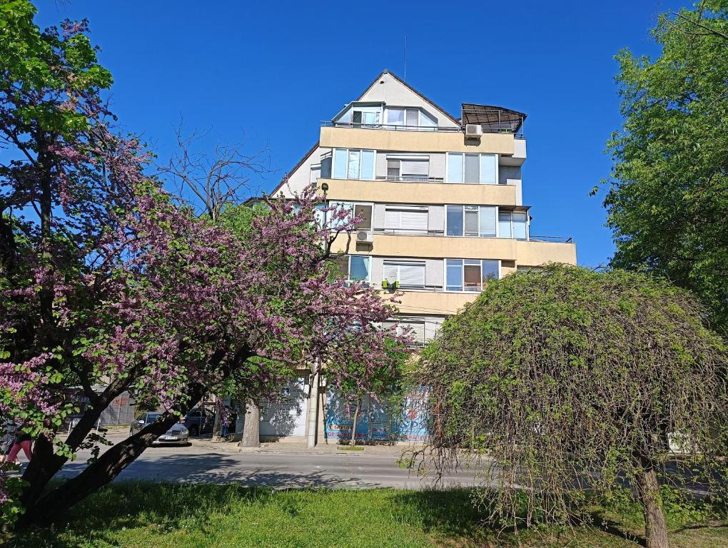 un edificio alto con alberi di fronte di MDM APARTMENT CITY CENTER FELICITA DeLUXE a Ruse