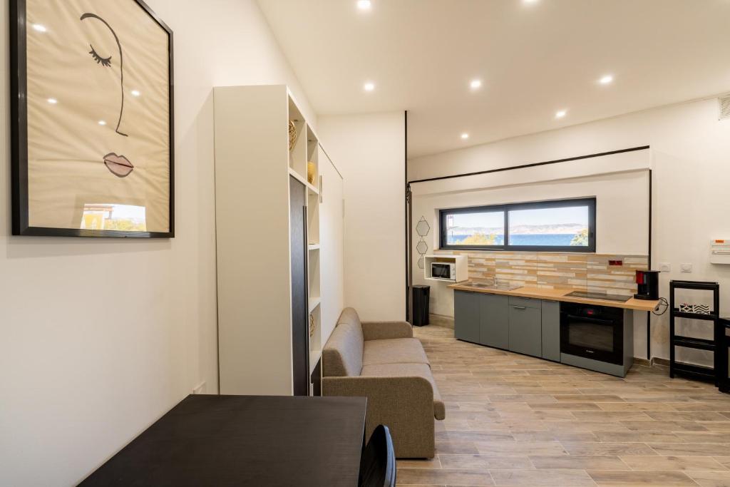 une cuisine et un salon avec un canapé et une table dans l'établissement Cosy studio magnifique vue mer, à Marseille