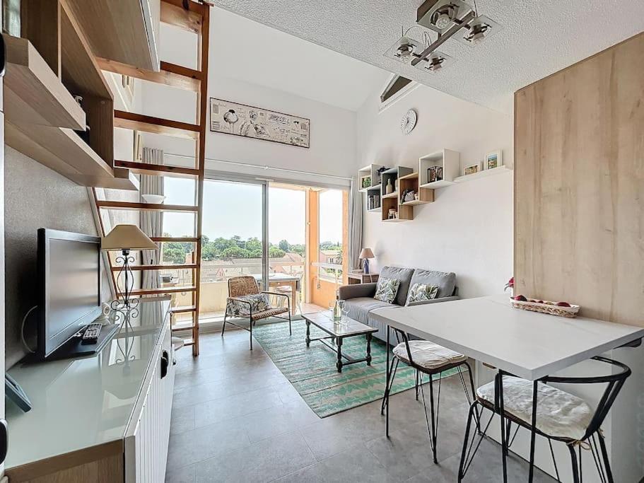 une cuisine et un salon avec une table et des chaises dans l'établissement 3476-Appartement piscine à 800m de la mer, à Argelès-sur-Mer