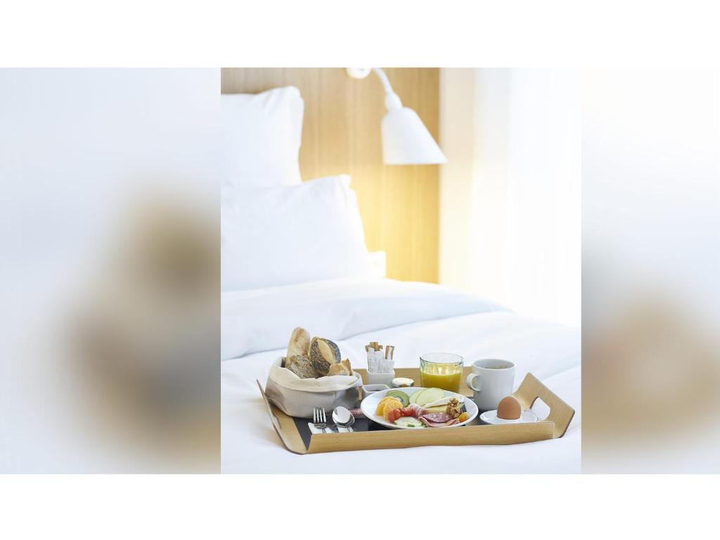 a tray with breakfast food on a bed at 9Hotel Republique in Paris
