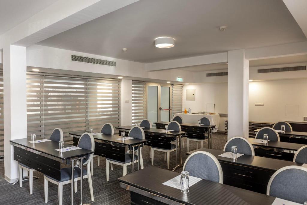 a dining room with tables and chairs at Park Beach Hotel in Limassol