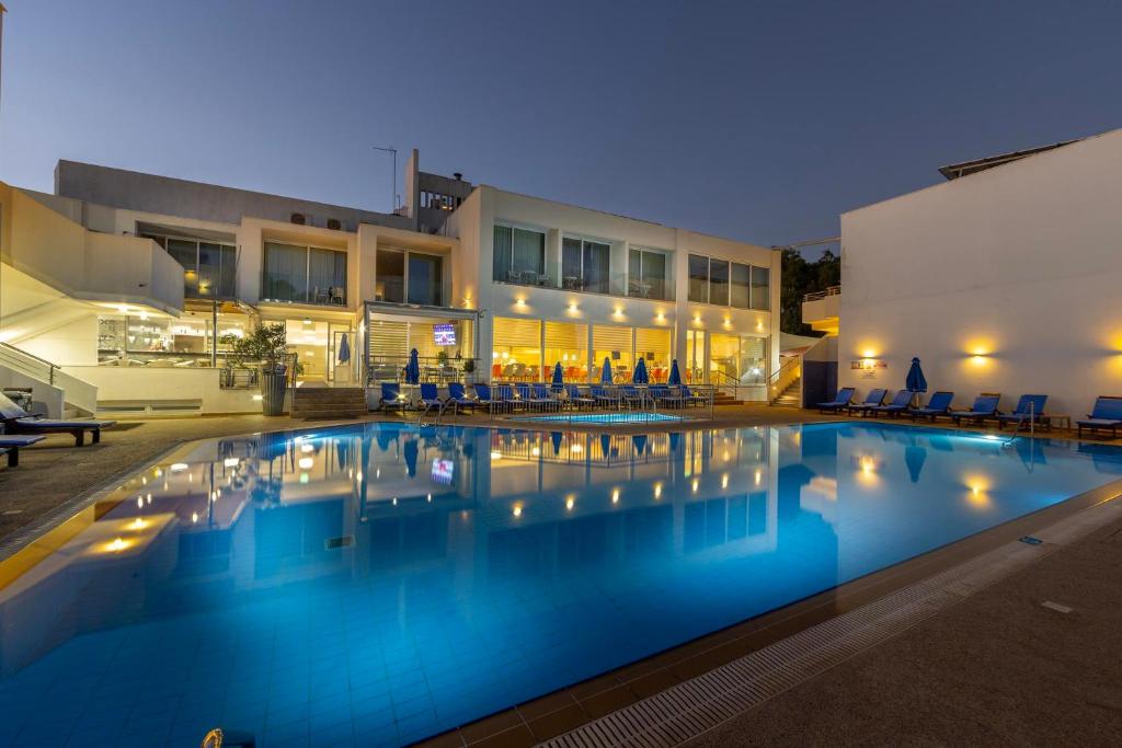a swimming pool in front of a building at night at Park Beach Hotel in Limassol
