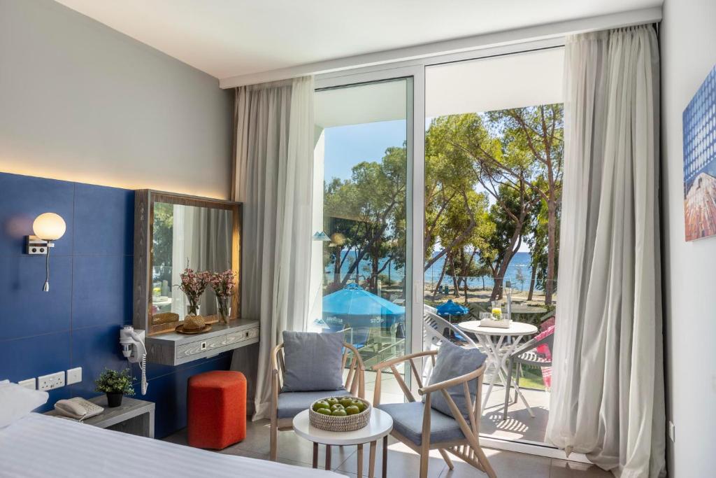 a bedroom with a bed and a room with a balcony at Park Beach Hotel in Limassol
